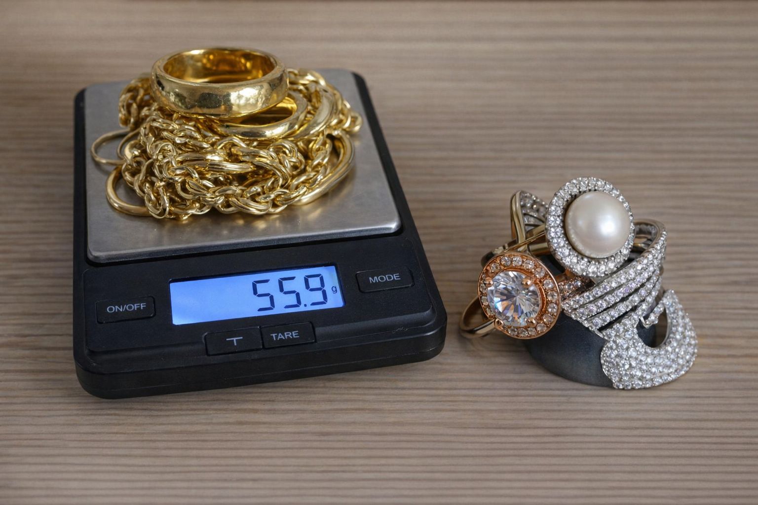 Guldringar och kedjor vägs på en digital guldvåg för värdering.
