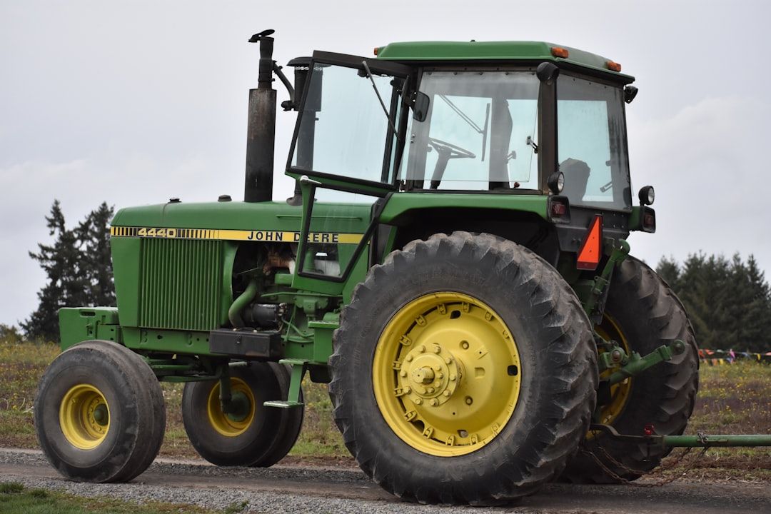 En grön och gul John Deere 4440-traktor på en väg.
